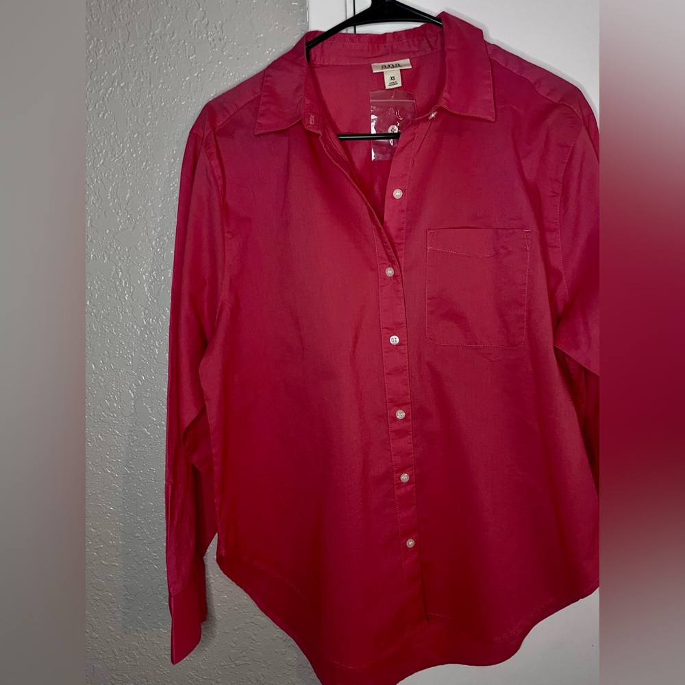 Woman’s pink button up blouse.